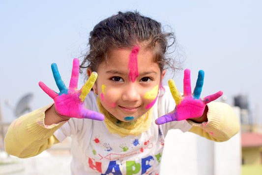 Kind das Holi Pulver an den Händen und im Gesicht hat