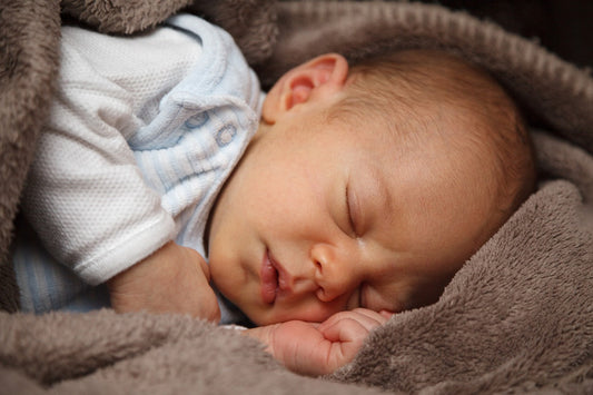 Baby das friedlich in eine Decke eingehüllt schläft